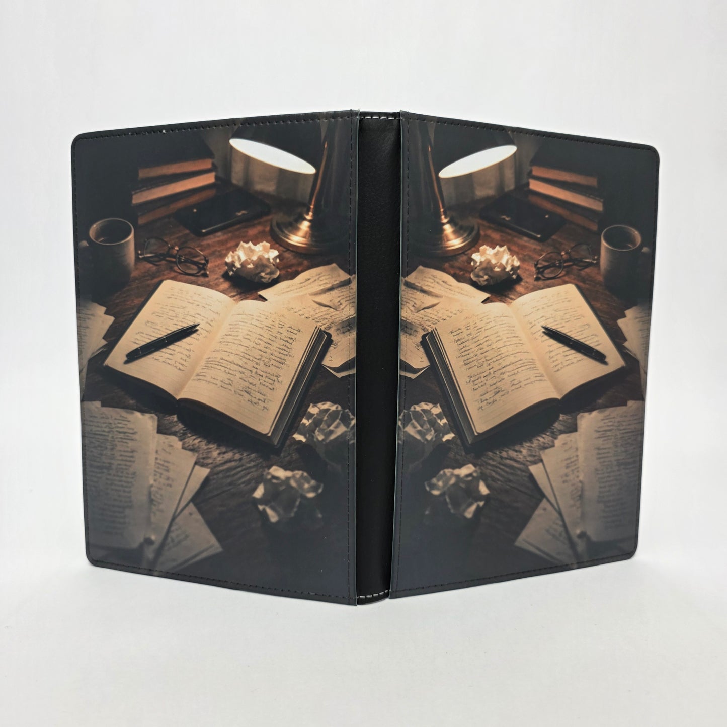 Journal cover design featuring books, papers, and a pen on a messy desk.