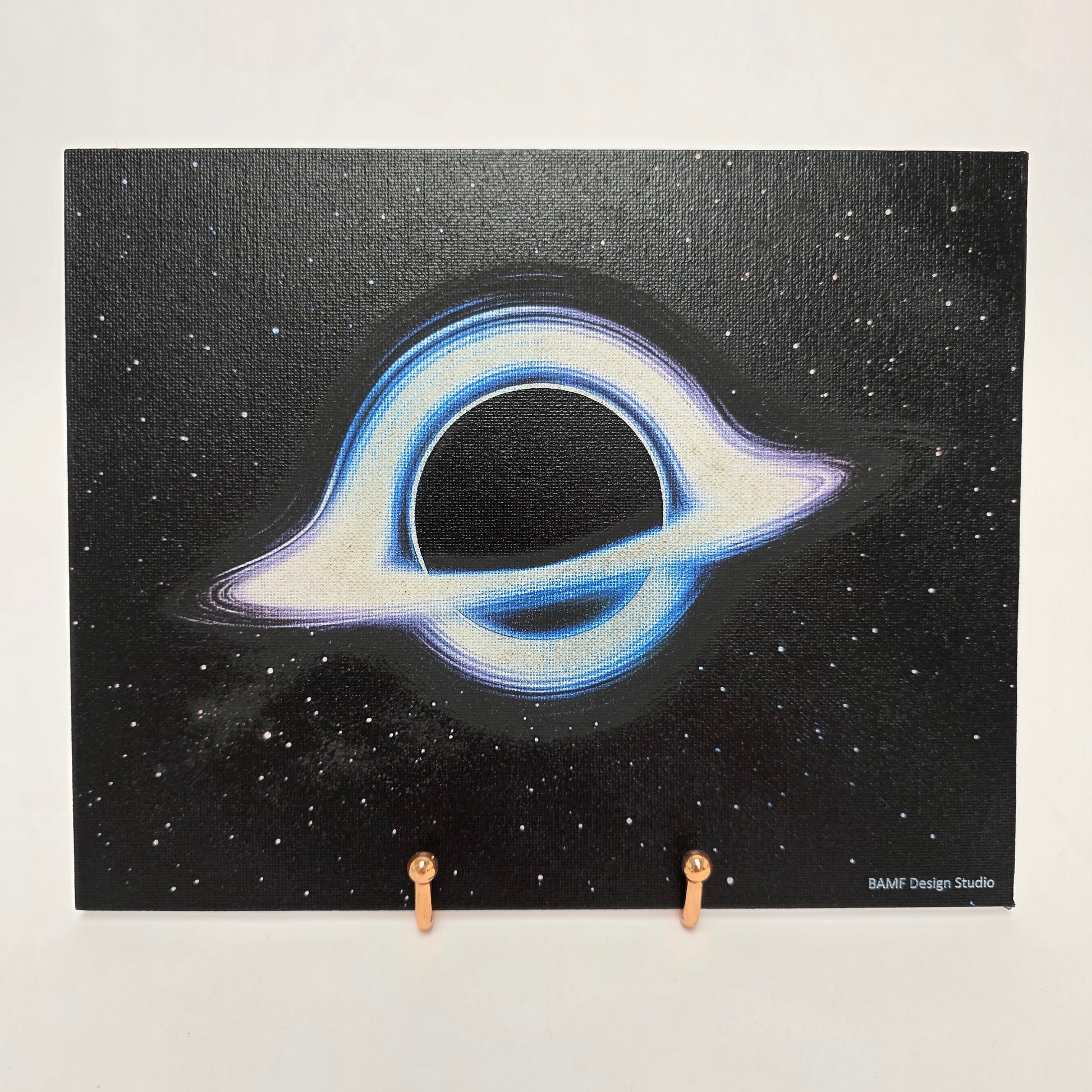 Canvas print of a cosmic black hole surrounded by blue and purple hues. Black starry background.