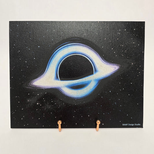 Canvas print of a cosmic black hole surrounded by blue and purple hues. Black starry background.