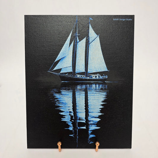 Canvas print of sailboat with reflection on water. Black and blue accents.