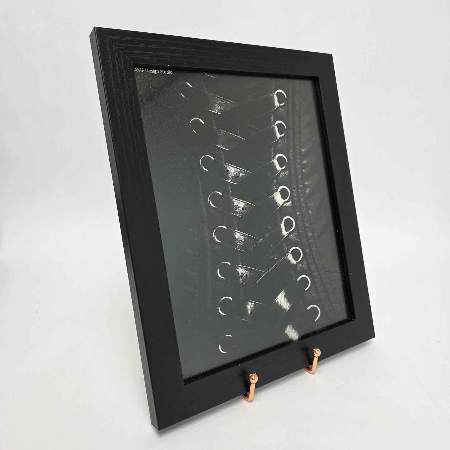 Black framed canvas with Image of a black and white laced corset.