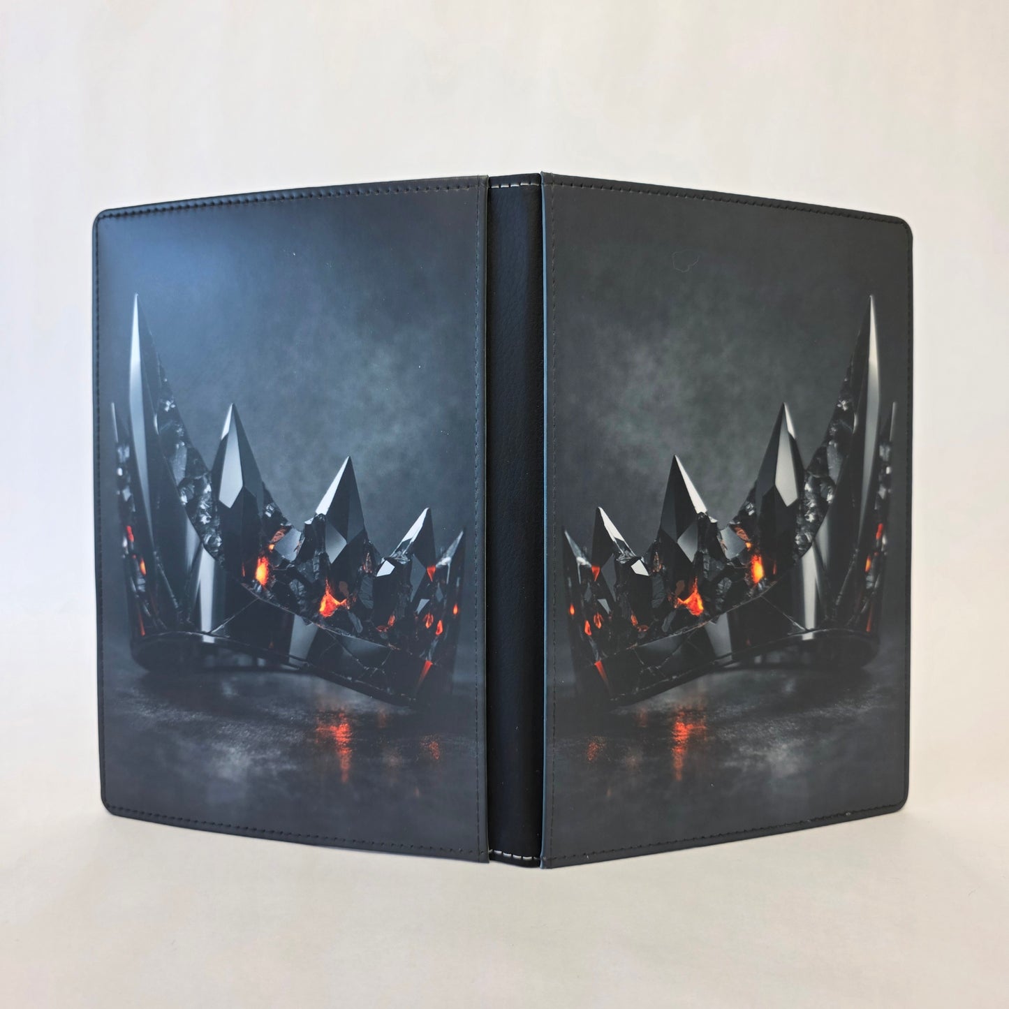 A journal cover featuring a black metallic crown with orange accents. Image on front and back.