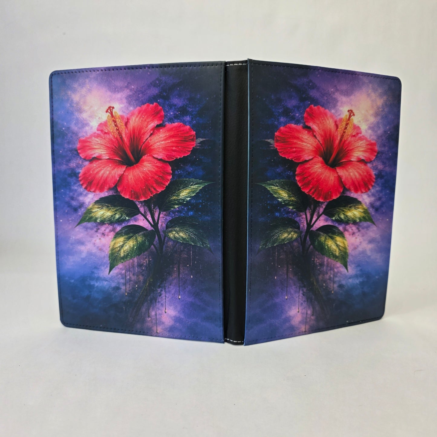 A journal cover with a pink hibiscus flower on a purple background.