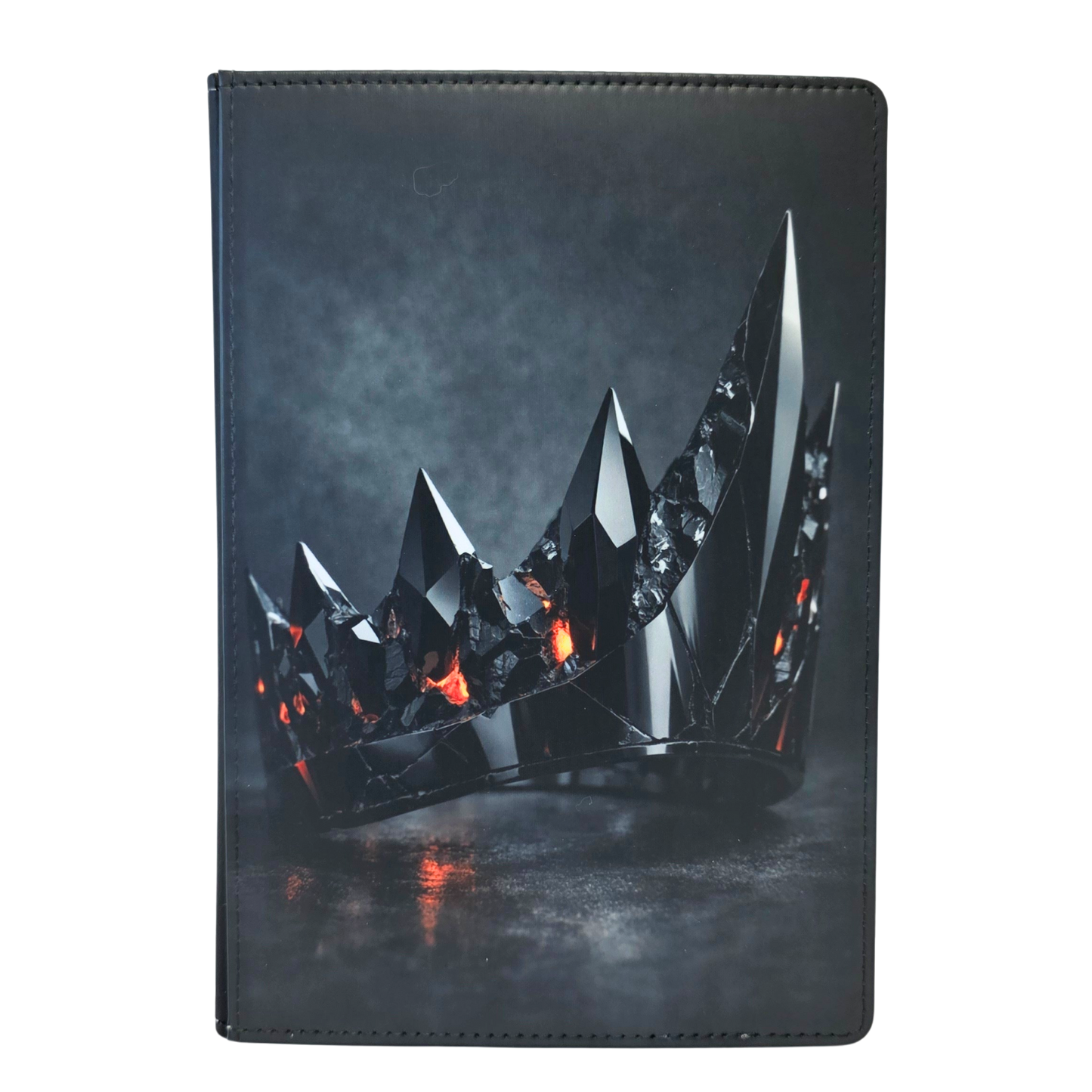 A journal cover featuring a black metallic crown with orange accents.